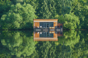 A house on the lake, with a dock for boats, lit by the low sun of the early morning.