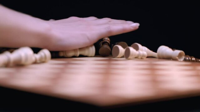 Caucasian Woman's Hand Knocks Down All Chess Pieces Off Chess Board - Close-up Macro, Rack Focus. Shot with ARRI Alexa in ArriRaw at 120 fps, exported 23.98 fps QuickTime Apple ProRes 422 HQ.