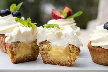 Cupcakes with different fruits on a white plate close-up.