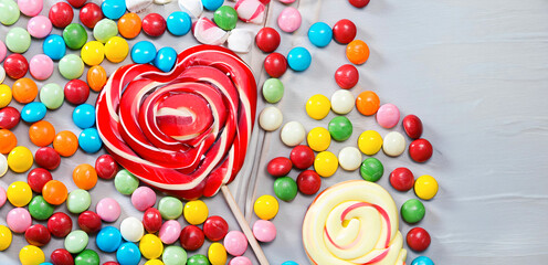 Fototapeta na wymiar Photo colorful lollipops and different colored round candy. top view