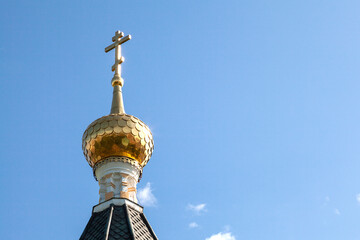 Fototapeta na wymiar The dome of an Orthodox church covered with golden tiles against the sky