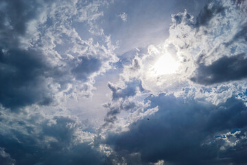 Dramatic cloudy sky landscape with a powerful sun between the clouds