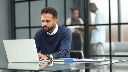 Fototapeta na wymiar African businessman working on a laptop in an office