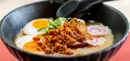 ramen bowls with noodles, pork, chicken, boiled egg and vegatables served with seaweed salad