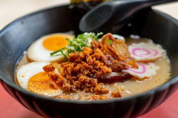 ramen bowls with noodles, pork, chicken, boiled egg and vegatables served with seaweed salad