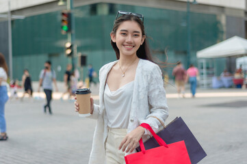 A beautiful and young asian female office employee smiles while walking around the city district....