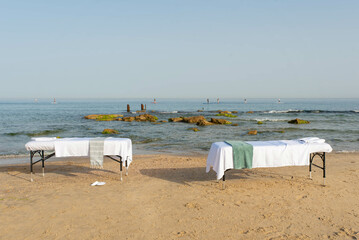 Massage table on the beach near the sea prepared by professional masseur for relax in tropical massage spa procedures.