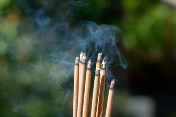 Incense burning in garden with blur background