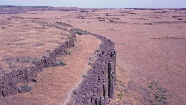 Hikers walk on top of volcanic basalt rock columns in WA Scablands