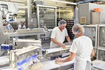 Worker in a large bakery - industrial production of bakery products on an assembly line