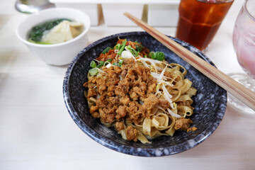 mie or bakmi ayam is a traditional Indonesian seasoned yellow wheat noodles topped with minced chicken meat served with mung bean sprouts, fried shallot, and a bowl of dumplings