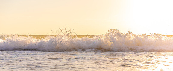 Natural scene of strong wave hit the beach with bright sunlight.