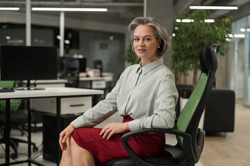 Mature caucasian woman at the desk in the office. 