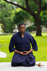 Handsome black martial artist man with martial arts costume of kendo doing meditation