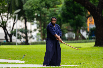 Fototapeta na wymiar Handsome black martial artist man with martial arts costume of kendo