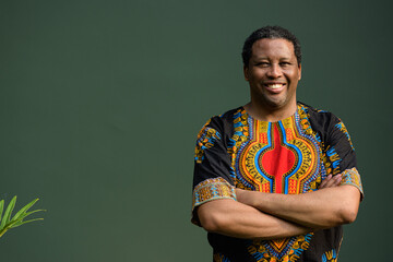 Portrait of handsome black man wearing traditional clothes with arms crossed while smiling