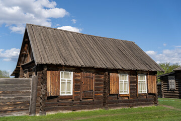 old wooden house against a blue sky with white clouds