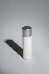 Cosmetic product in tube, bottle, lotion or serum on grey background.