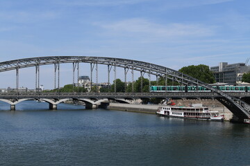 Parisian subway passing on an iron bridge overlooking the seine. 