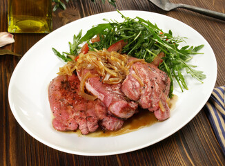 Fine Meat - Boiled Cured Veal Tongue Meat Slices with roasted Onions and Salad  on wooden Background