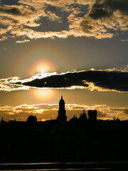 Enchanting Sunset over Kiev-Pechersk Lavra: Sun Emerging from Clouds, Casting Reflections on the Dnieper River