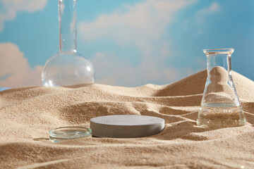 Laboratory concept on the the beach sand with a round podium in gray color. Natural skin care...