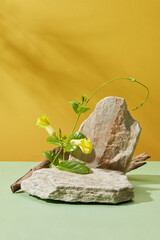 Stone podiums decorated with green leaves and yellow flowers. Blank space on the stone for product advertising