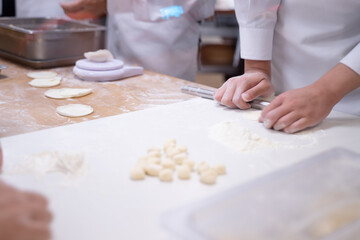 Hands of a young woman in an apron holding a rolling pin on a table. ,Create the dough, baking, baking ideas, homemade bakery. shooting while moving