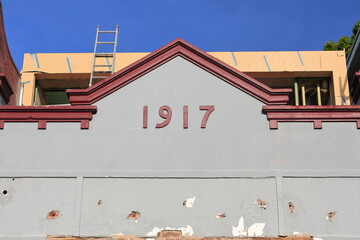 Gray facade of AD 1917 built terrace house under restoration on Ormond Street, Paddington....