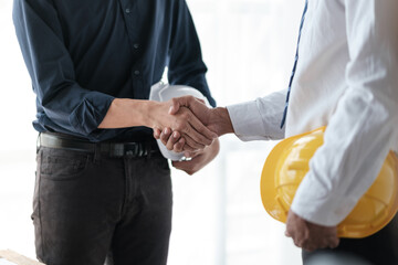 Close-up image of an engineer shaking hands with his coworker during the meeting. teamwork, building trust, unity
