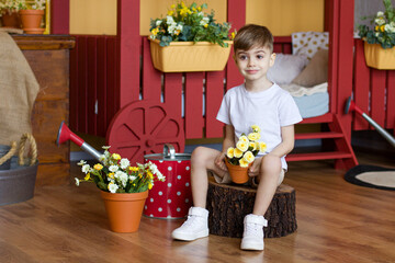 A boy is sitting with flowers in the studio