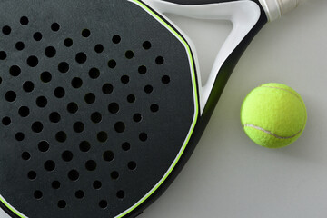 Detail of black and white paddle tennis racket and ball
