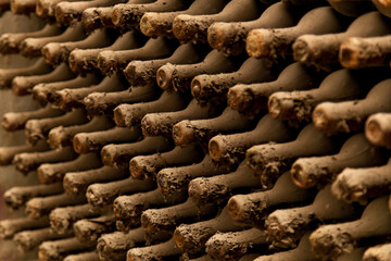 Old bottles of wine stacked in rows