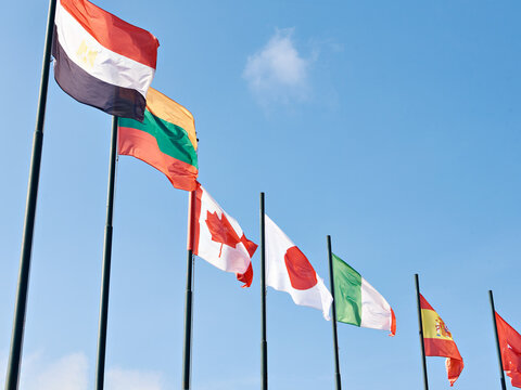 Canada, Japan, Italy, Spain, Lithuania, Egypt flags on sky