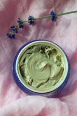 jar with cream on pink linen fabric