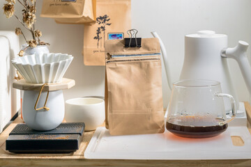 Coffee maker , a jug of black coffee and a coffee bean bag
