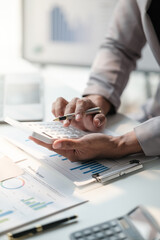 Close up young man with calculator counting making notes at home, hand is writing in a notebook. Savings finances concept