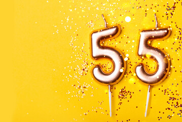 55 years celebration. Greeting banner. Gold candles in the form of number forty on yellow...