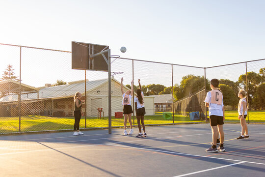 children training for netball on outdoor court