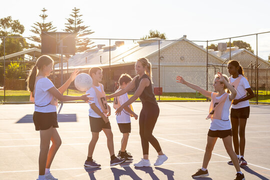 parent coaching kids netball team with boys and girls