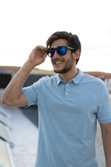 Portrait of a young man with glasses: A sunlit day frames the confident gaze of a stylish young man, capturing his youthful charm.