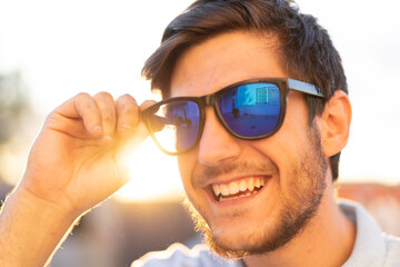 Portrait of a young man with glasses: A sunlit day frames the confident gaze of a stylish young man, capturing his youthful charm.