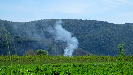Toskana in Italien mit Rauchwolke vor Hügel