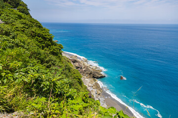 Fototapeta premium Stunning view reveals the grandeur of the cliffs at Taiwan southeast coast, Qingshui Cliff near Taroko National Park. Towering and lush, they overlook the azure sea, evoking a sense of awe. Landscape
