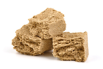Pieces of sunflower halva, isolated on white background.