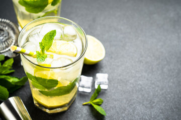 Mojito with rum and lime on black background. Traditional Summer iced drink.