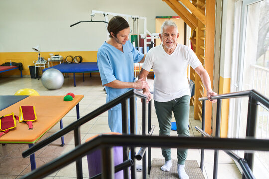 Physiotherapist assisting elderly man in movement therapy