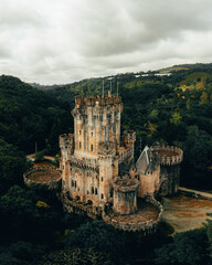 An enchanting aerial view of Butron Castle, nestled amidst lush greenery, exuding a sense of history and grandeur.