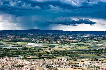 Vue panoramique  avec ciel d'orage sur la région de l'Emporda (Espagne) et sur le village de Torroella de Montgrí dans la province de Gérone. - 615760792
