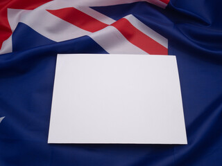 Top view of a blank white paper on the Australia flag background.